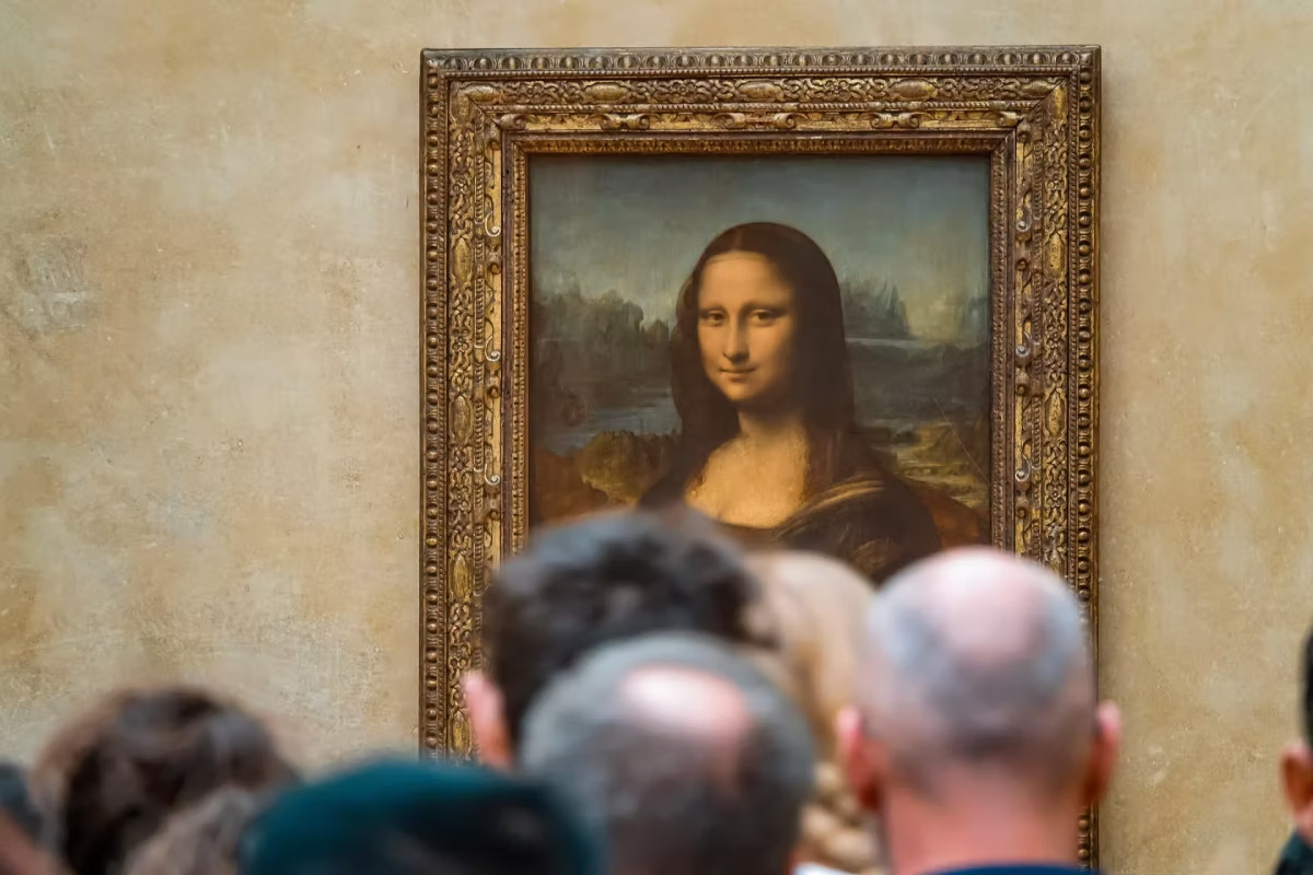 Visitors gather to view the Mona Lisa painting inside the Louvre Museum.