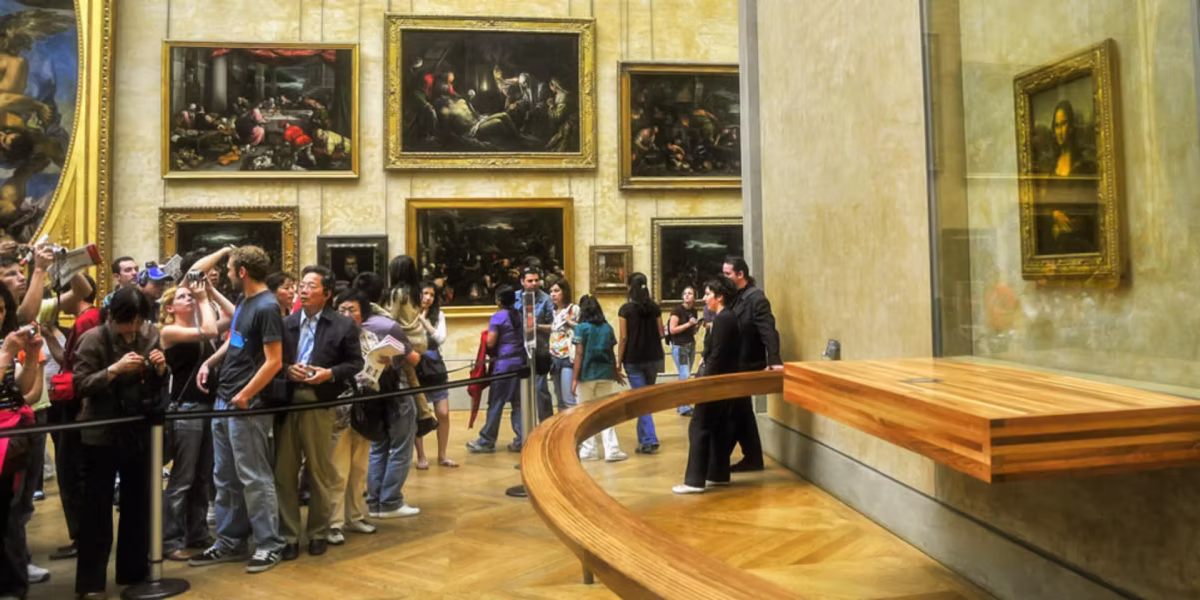 Visitors gather near the Mona Lisa painting inside the Louvre Museum.
