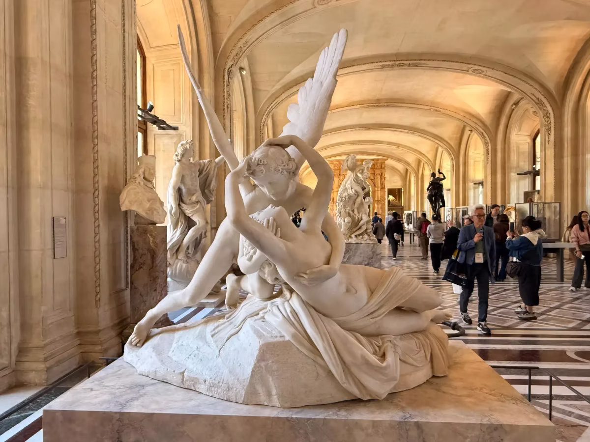 The Psyche Revived by Cupid sculpture is displayed in a gallery at the Louvre Museum.