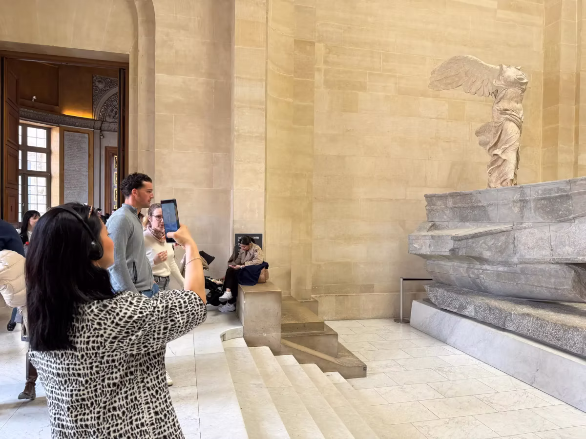Visitors take photos of the Winged Victory of Samothrace inside the Louvre Museum.